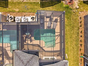 An aerial view of a rooftop with a swimming pool, outdoor seating, and air conditioning units. - 5BRStorey Lake Resort | Private Pool | Near Disney (Kissimmee)