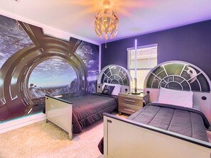 Un dormitorio con dos camas, un ventanal grande y un original diseño de pared circular.