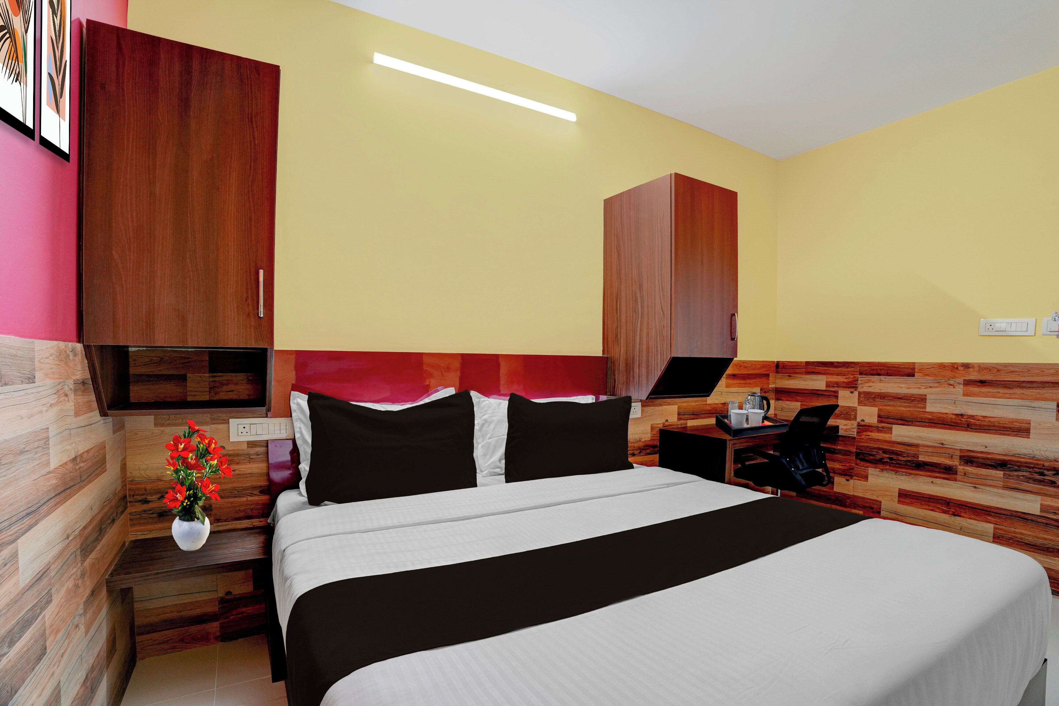 Ein Hotelzimmer mit Bett, Nachttisch, Schreibtisch und Stuhl.