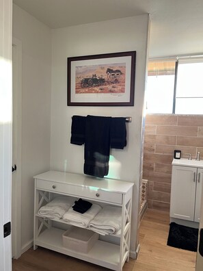 A bathroom with a white vanity, a framed picture on the wall, and a towel rack. - Inviting 3-Bedroom Sonoita Escape: The Ideal Arizona Wine Country Getaway (Sonoita)