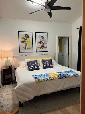 A bedroom with a bed, two wall-mounted pictures, a bedside lamp, and a ceiling fan. - Inviting 3-Bedroom Sonoita Escape: The Ideal Arizona Wine Country Getaway (Sonoita)