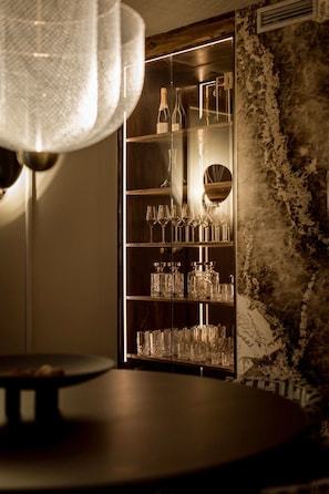 Eine Bar mit einem Holzschrank, der Flaschen und Gläser beherbergt.