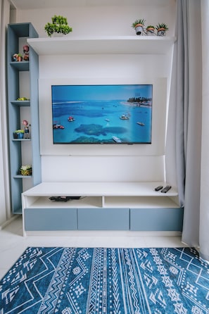 A flat-screen TV mounted on a white entertainment unit with a coastal scene. - New Listing (Ipojuca)