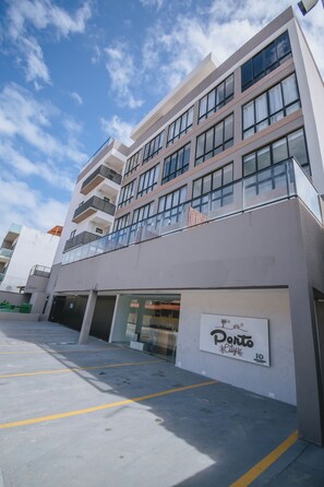 A multi-story building with a sign indicating 'Ponto City' and a parking lot in front. - New Listing (Ipojuca)