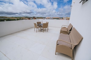 A rooftop terrace with a table and chairs, a sofa, and a view of the surrounding landscape. - New Listing (Ipojuca)