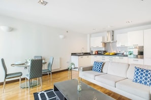 A modern apartment with a dining area, kitchen, and living room. - Battersea River View Apartment (London)