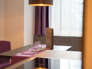 A hotel room with a dining table set for two, a book, and two glasses. - Augl´s Hof by Interhome (Ischgl)