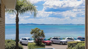 Une vue sur la côte, avec des voitures garées et un ciel dégagé.