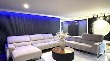 Una sala moderna con un sofá modular, una mesa de centro redonda y una obra de arte grande en la pared.