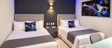 A hotel room with two beds, a desk, and a wall-mounted air conditioner.