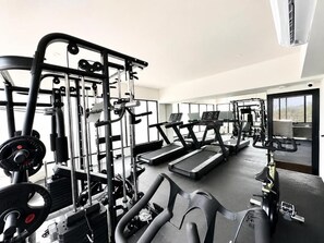 A gym with exercise equipment, treadmills, and weightlifting stations. - Hotel Mission Space 360 (Cancún)