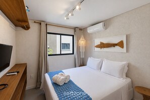A hotel room with a bed, a TV, a desk, and a window. - Apt. w/ Priv. Pool 740m to Beach Clb0027 (São Miguel dos Milagres)