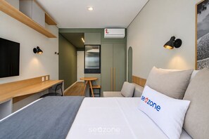 A hotel room with a bed, a desk, a chair, a small table, and a TV. - Studio Well Located in Condo. Pti0304 (Florianópolis)
