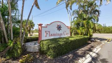 Un panneau indiquant l’accès à Flamingo Cay, avec une route dégagée et des palmiers en arrière-plan.