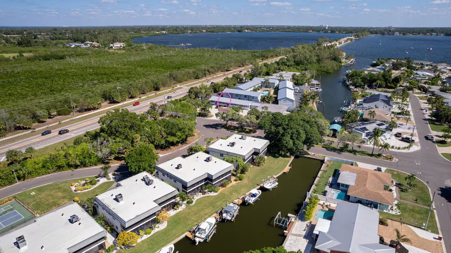 Un quartier résidentiel comprenant un port de plaisance, des maisons et une route.
