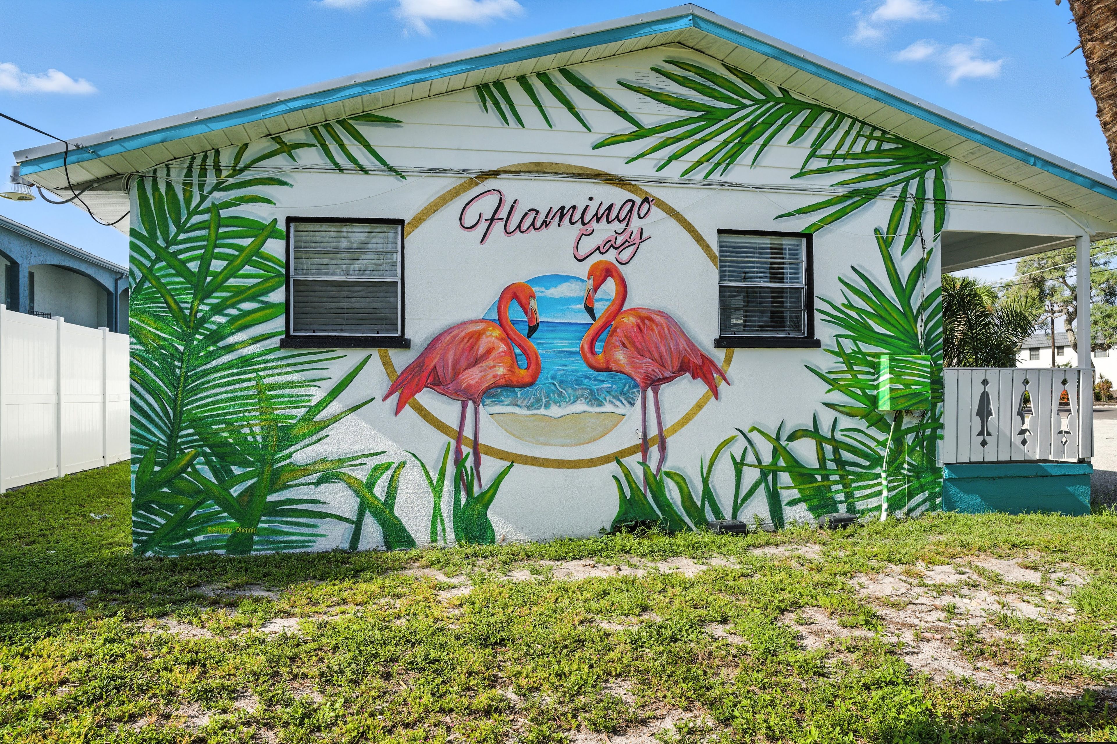A building with a mural of flamingos and palm leaves, and the text 'Flamingo Café' on the side.