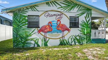 A building with a mural of flamingos and palm leaves, and the text 'Flamingo Café' on the side.