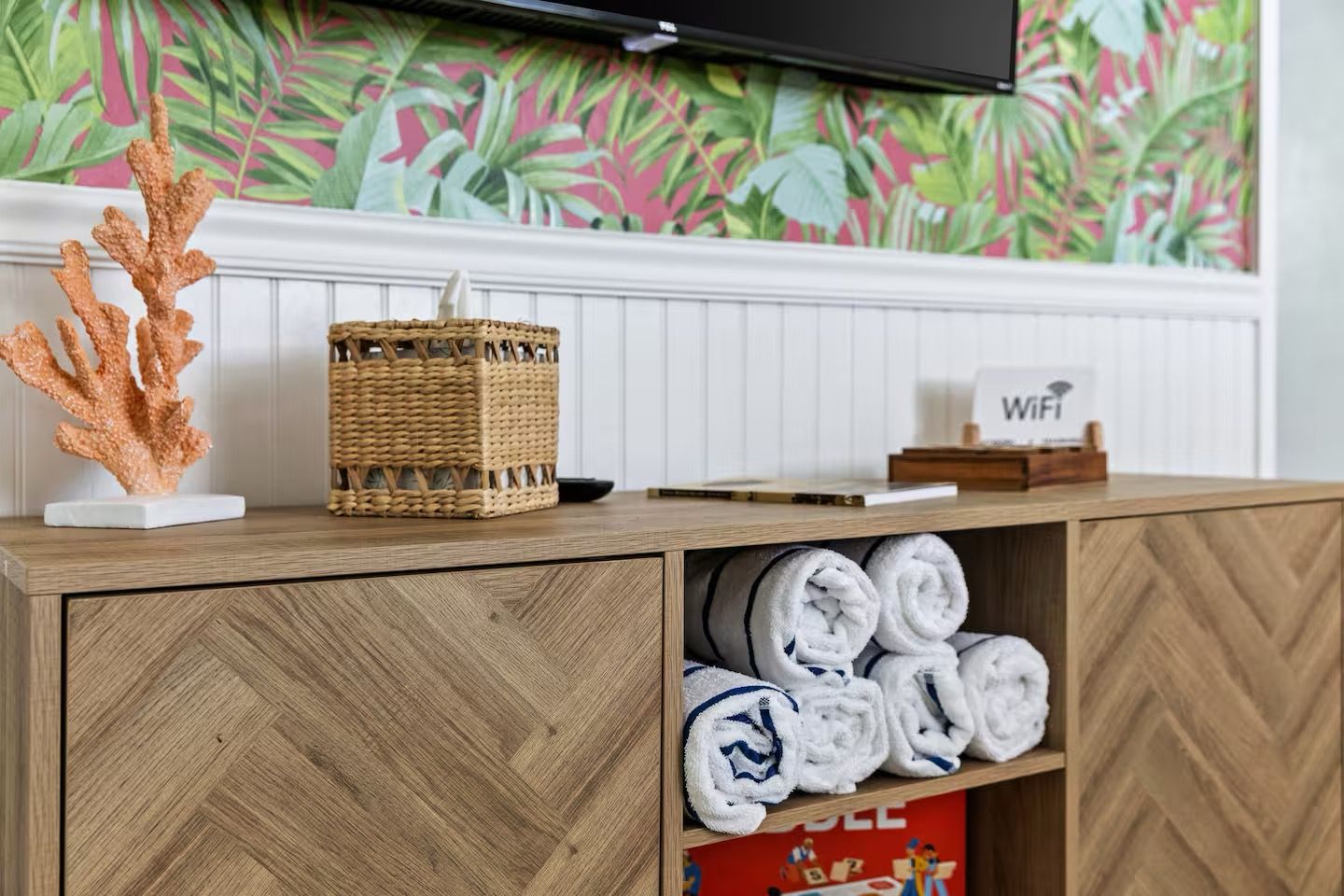 Una barra de madera con una cesta tejida, un cartel de WiFi y toallas enrolladas.