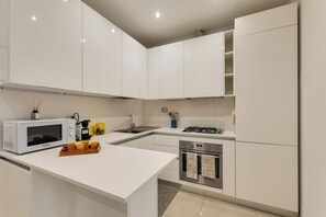A modern kitchen with white cabinetry, a built-in microwave, a gas stove, and a dishwasher. - New Listing (Roma)