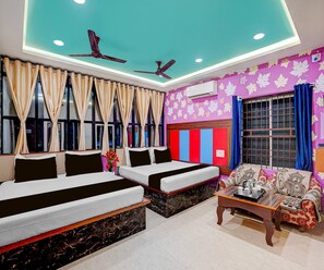 A hotel room with two beds, a sofa, a coffee table, and a ceiling fan. - Classic Hotel Sunshine (Gop)