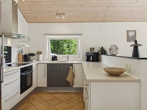 A modern kitchen with a window, stainless steel appliances, and a tiled floor. - Vacation home "Elle" by Interhome (Toftlund)