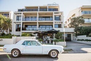 A white vintage car parked in front of a modern building with a sign reading 'CHALET &'. - Kayannee II - Ocean views, 4 beds, AC (Sunrise Beach)