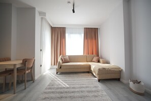 A modern living room with a sofa, a dining table, and chairs. - Serene 1-bedroom condo in Samsun perfect for a relaxing getaway (Samsun)