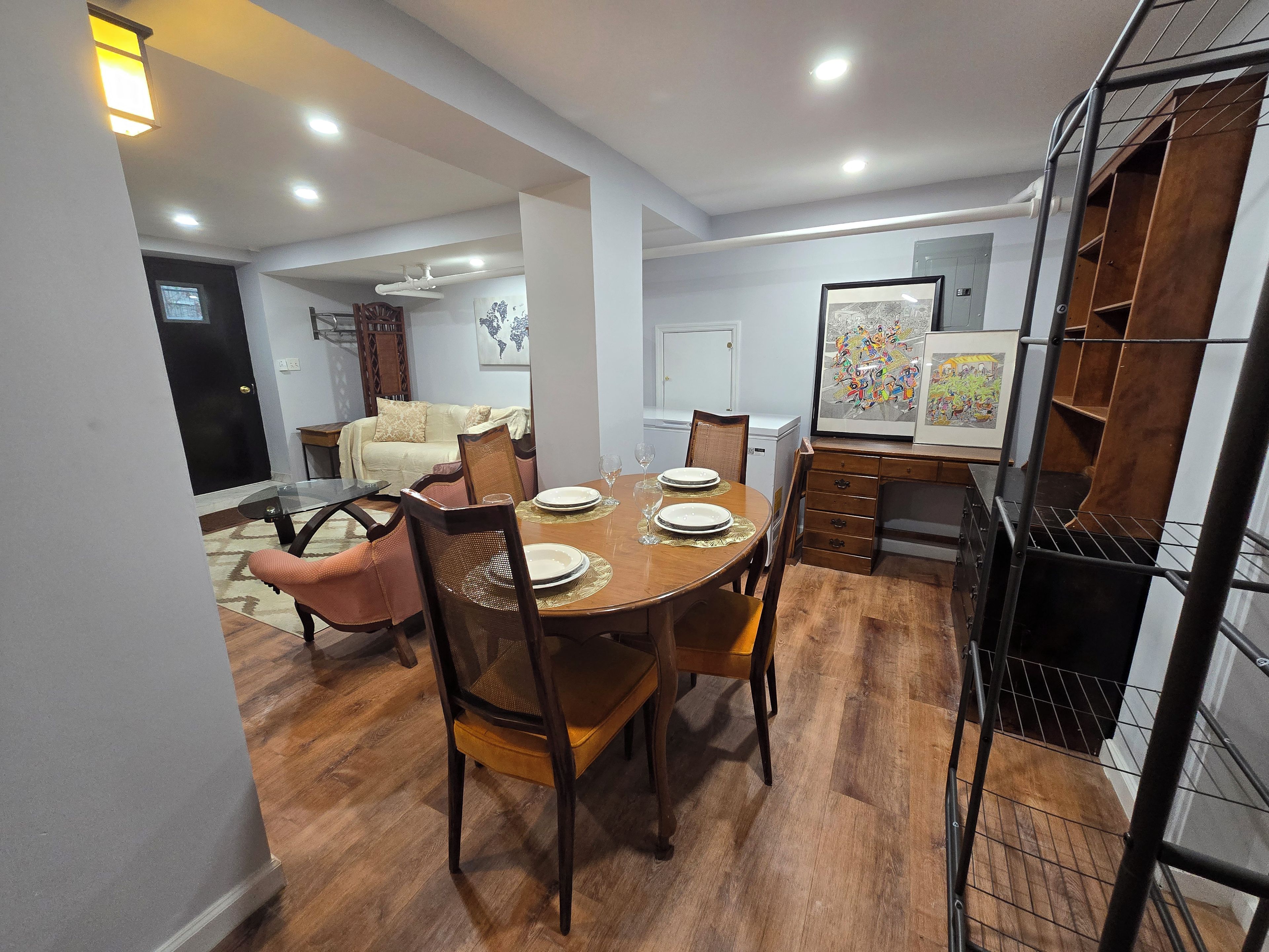 Uma área de refeições com mesa de madeira, cadeiras e um aparador para buffet.