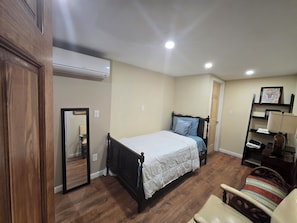 A bedroom with a bed, a chair, a wardrobe, and a mirror. - Historical 2BR APT in Brooklyn NY (Brooklyn)