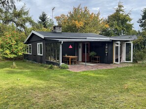 Una casa negra con un patio, una mesa y sillas.