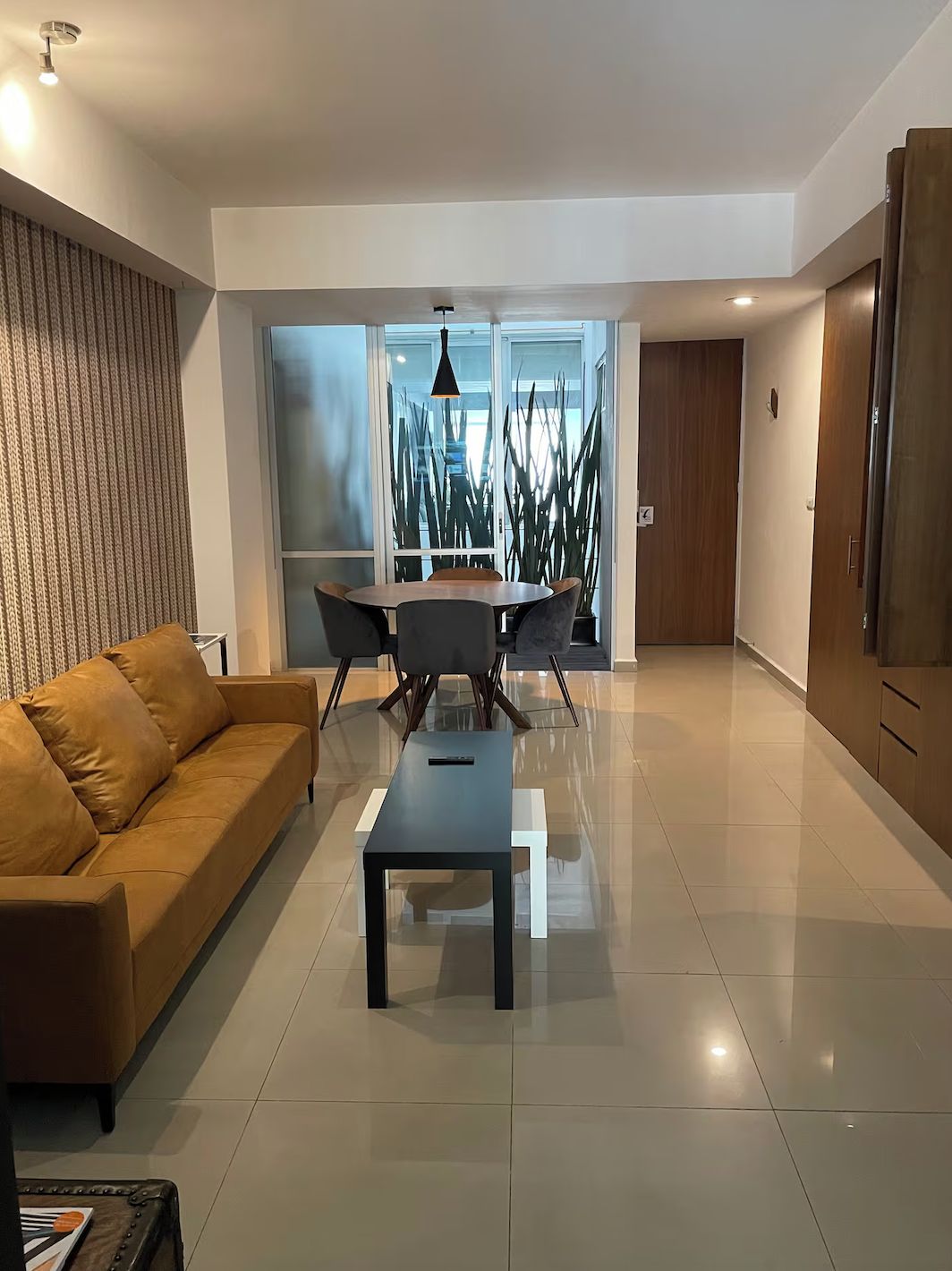 Una sala de estar moderna con un sofá, una mesa de centro y un comedor con sillas y una mesa.
