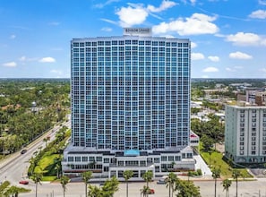 Een hoog hotel met een moderne glazen gevel, genaamd 'EDISON GRAND', met een opvallend bord bovenaan.