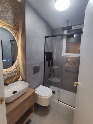 Ein Badezimmer mit weißem Waschbecken, WC und Duschkabine.
