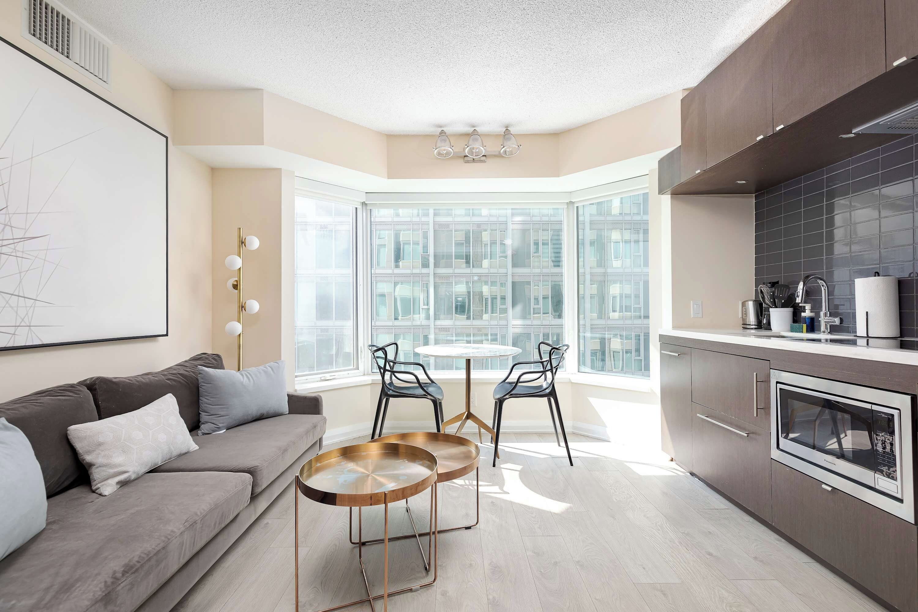 A modern kitchen with a built-in oven and a dining area with a round table and chairs.