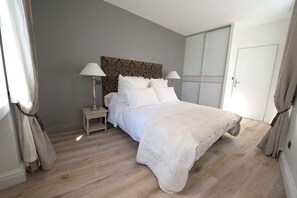 A bedroom with a bed, nightstands, lamps, a wardrobe, and curtains. - New Listing (Bordeaux)