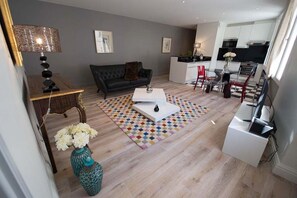 A modern living room with a sofa, coffee table, and a patterned rug. - New Listing (Bordeaux)