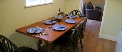 A dining table set with blue plates, silverware, and wine glasses.