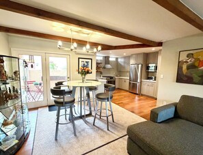 A modern kitchen with a central island, bar stools, and a dining table. - Walk to Plaza, 2BR/2.5BA Townhouse, Best for extended vacation, relocation, LANL (Santa Fe)