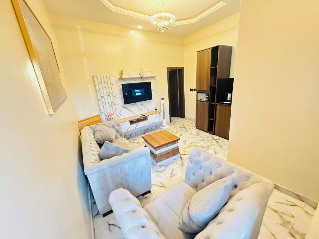A living room with a sofa, a coffee table, a TV, and a cabinet.