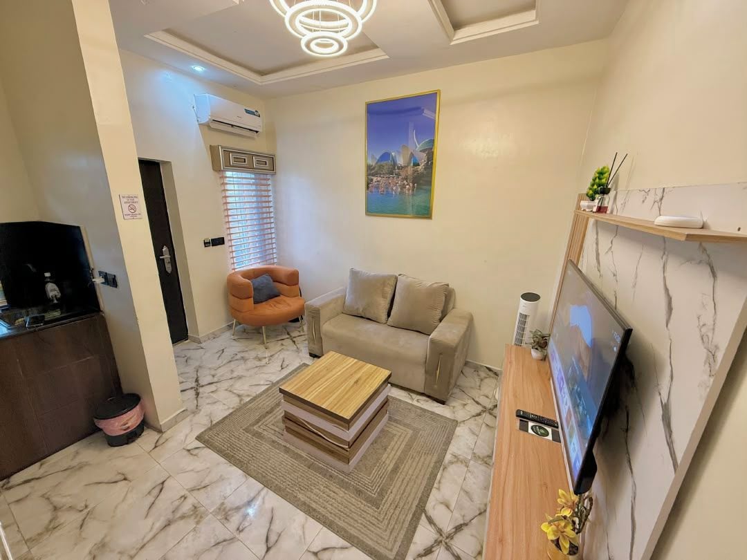 A living room with a sofa, a coffee table, a TV, and a painting on the wall.