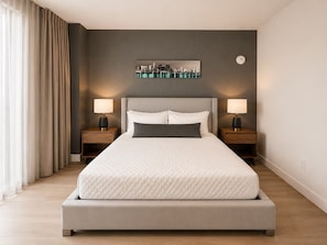 A modern bedroom with a large bed, two bedside tables, and a cityscape artwork on the wall. - Enjoyable 1-bedroom apartment in peaceful Miami neighborhood (Miami)