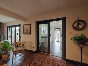 A living room with a sofa, a chair, a radiator, a rug, and a large window. - 2 Bed in Hordle (oc-m46569) (Hordle)