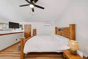 A bedroom with a bed, wooden headboard, a ceiling fan, an air conditioning unit, a television mounted on the wall, and a window with blinds. - Premium Cabana - Outdoor Jacuzzi (Tijeras)
