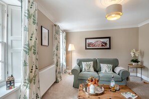 A living room with a sofa, a coffee table, a lamp, and a framed picture on the wall. - 2 Bed in Kelso (oc-k46033) (Kelso)