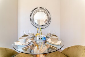 A round glass table set for dining with a decorative mirror above it. - 2 Bed in Winchburgh (oc-h44720) (Broxburn)