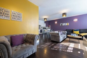Ein modernes Wohnzimmer mit einer Couch, Sesseln und einem Couchtisch.