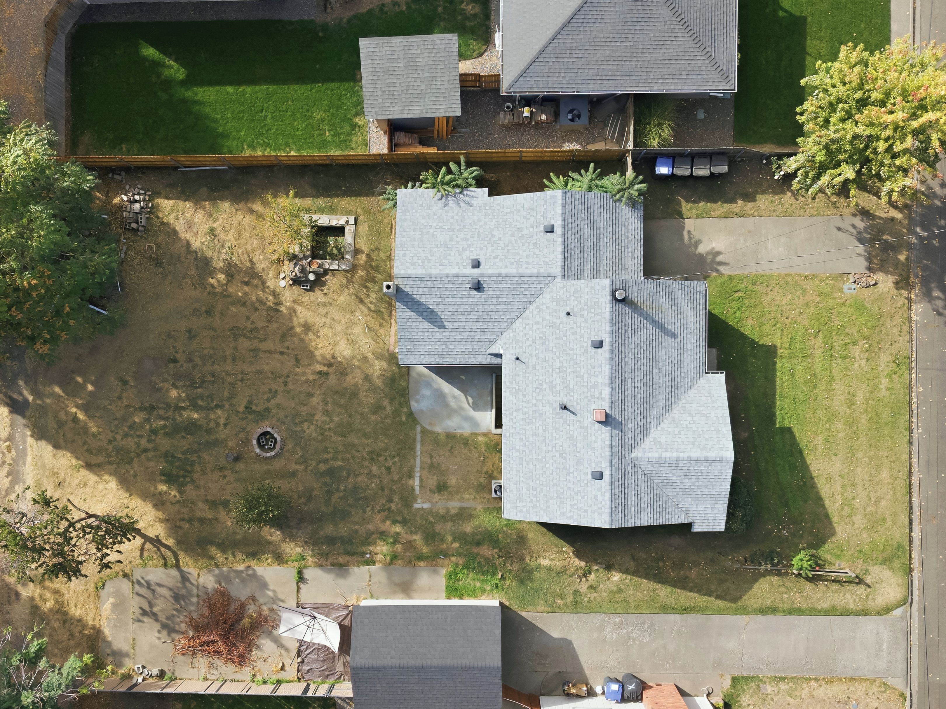 An aerial view of a residential area with multiple houses, a well-maintained lawn, and a clear sky.