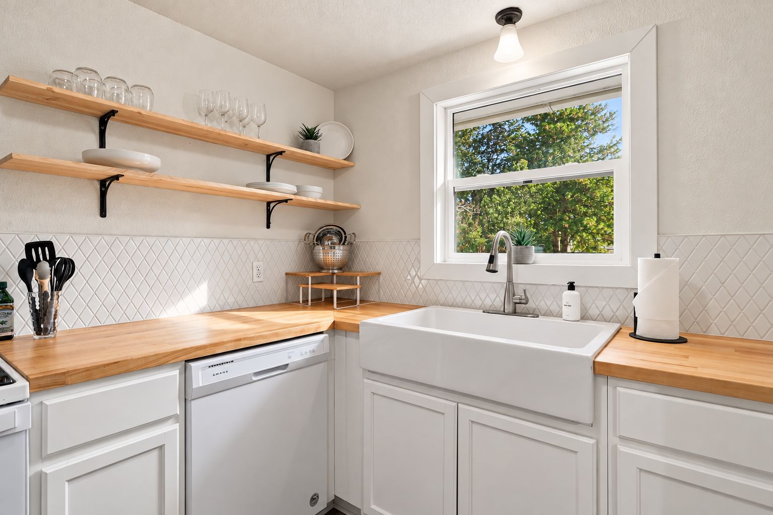 Eine moderne Küche mit weißen Schränken, Holz Arbeitsplatten, einem eingebauten Geschirrspüler und einem Fenster mit Blick auf Bäume.