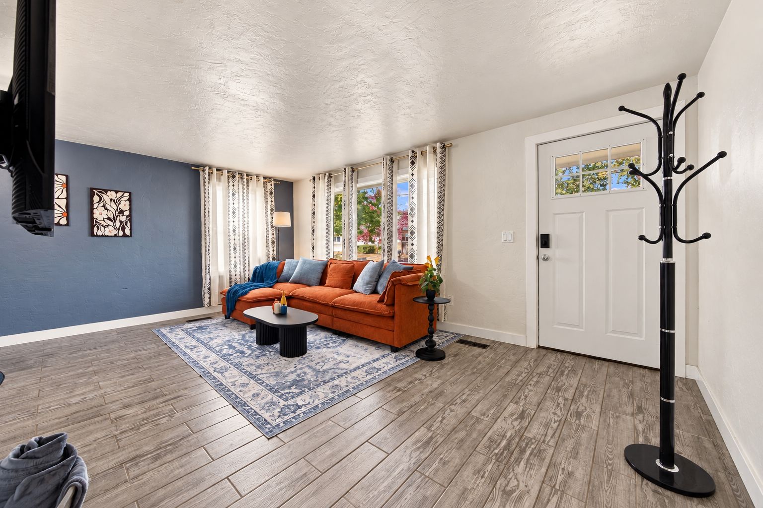 A living room with a sofa, coffee table, and patterned rug.