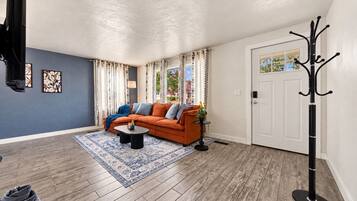 A living room with a sofa, coffee table, and patterned rug.